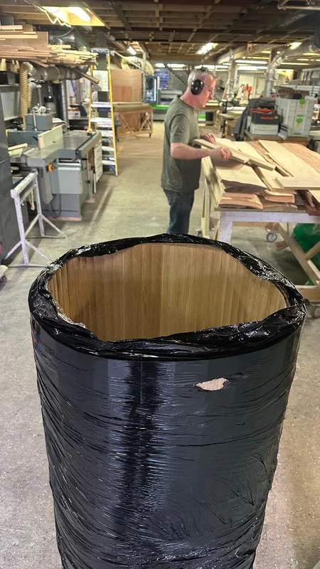 Flexible fluted timber veneer rolled into a cylinder in the workshop