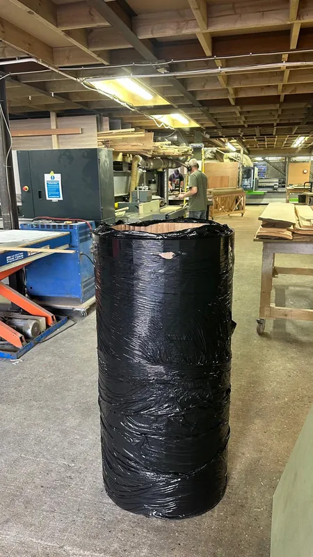 Wrapped roll of curved fluted veneer ready for dispatch
